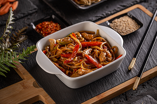 Plate of Asian food, pasta with chicken meat and vegetables