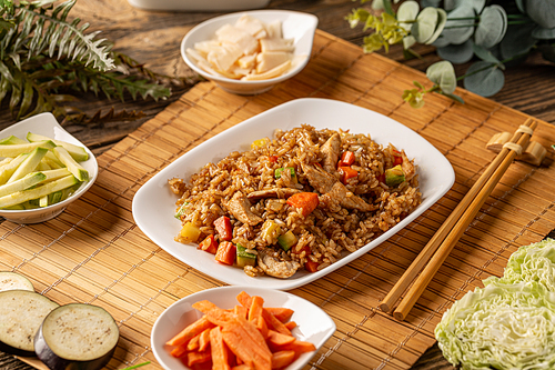 Plate of chinese fried rice with vegetables and chicken stripes