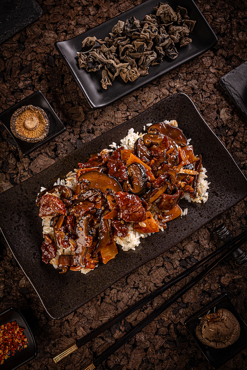 Slices of beef in spicy brown sauce with bamboo and shiitake served with boiled white rice