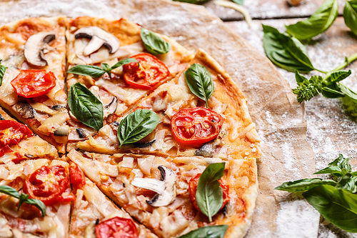 Composition of tasty pizza decorated with basil leaves