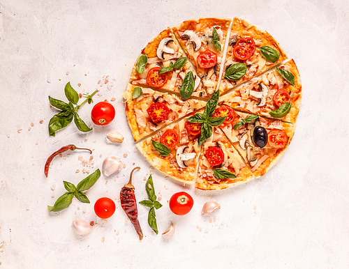 Italian pizza with tomatoes and mushroom, decorated with basil leaves