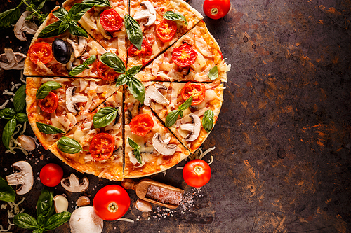 Composition with pizza, cherry tomatoes, mushroom and fresh basil on grungy background