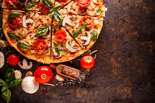 Composition of Italian pizza with its ingredients on rusty background