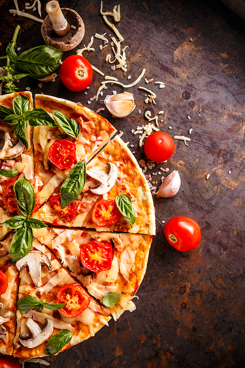 Top view of homemade Italian pizza on rusty background and fresh ingredients