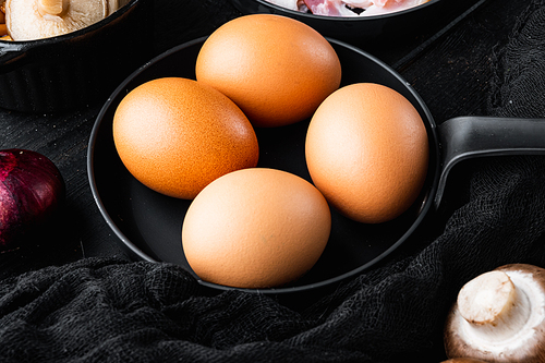 Chicken eggs in an egg box tray set, on black wooden table background