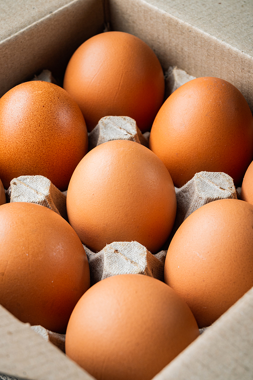 Chicken eggs in an egg box tray set, on black background