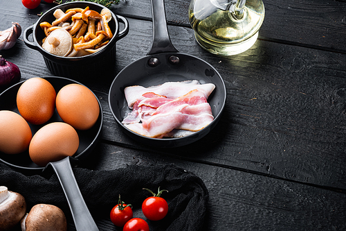 Breakfast egg ingredients mix, on black wooden table background, top view flat lay , with space for text copyspace