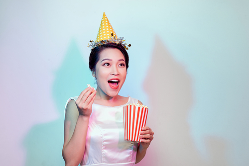 Amazing cute young pretty girl on the light background eats popcorn, wearing a white body dresses, fashionable Pin up girl, cool, smiling