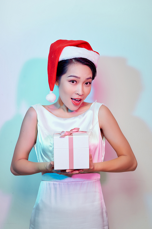 Beautiful happy asian woman in Santa Claus hat with christmas gift