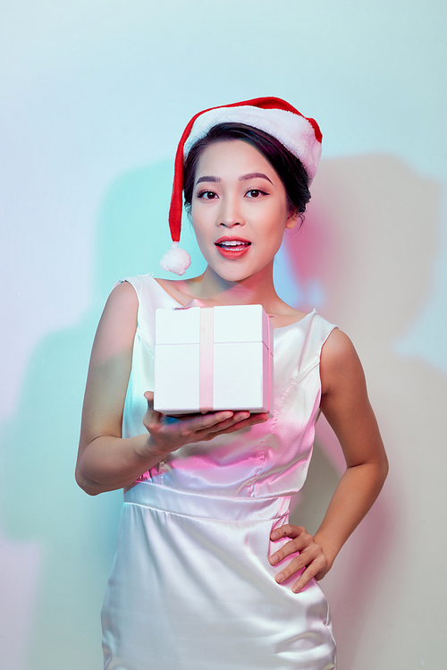 Beautiful happy asian woman in Santa Claus hat with christmas gift