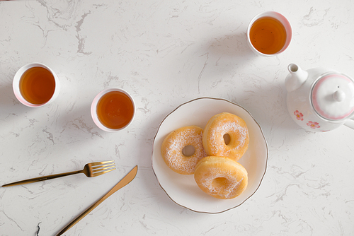 Classic donut. Morning breakfast with tea on table in living room at home.