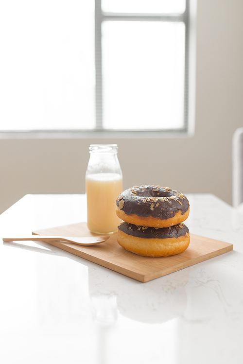 Chocolate donut. Morning breakfast with milk on table in living room at home.