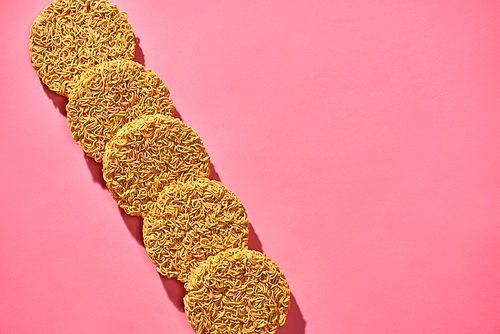 Dried instant noodles isolated on a pink background