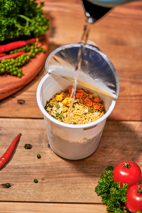 instant noodle, asian fast food, noodle cup on wooden background.