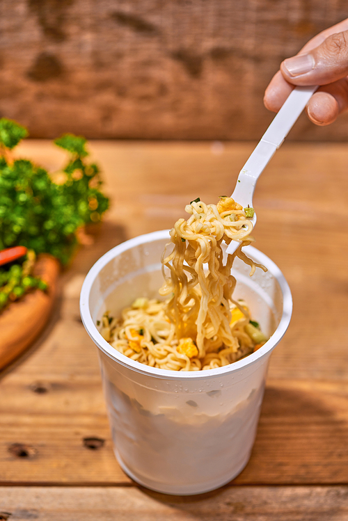 instant noodle, asian fast food, noodle cup on wooden background.