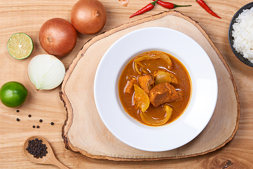 spicy chicken and rice on wooden background