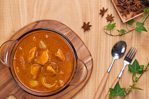 Chicken curry with spice on wooden background