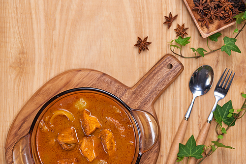 Chicken curry with spice on wooden background