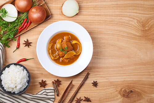 spicy chicken and rice on wooden background