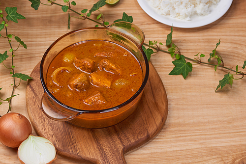 Chicken curry with spice in pot on wooden background