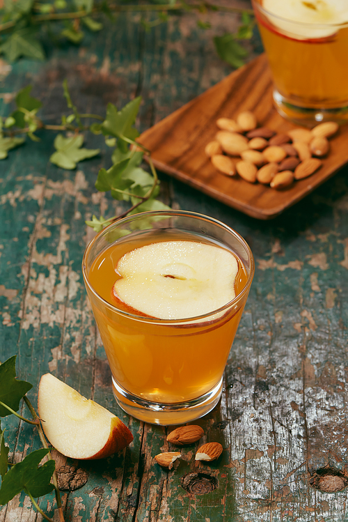 Hot drink of apple tea with cinnamon stick. Hot drink with apples for autumn or winter.