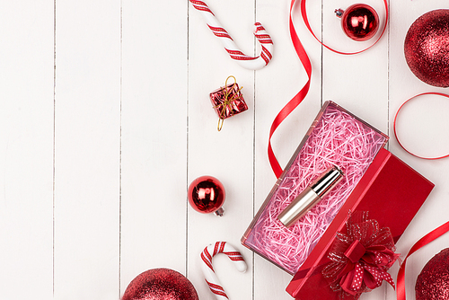 Flat lay of christmas ball, gift and cosmetic. Holiday Background. Beauty concept.