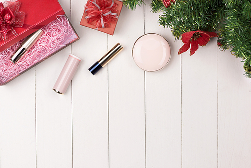 Cosmetic products in gift box on wooden background