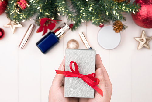 Cosmetic products in gift box on wooden background