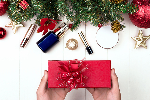 Cosmetic products in gift box on wooden background