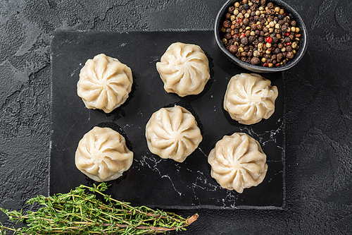 Chinese baozi dumplings on a marble board. Black background. Top view.