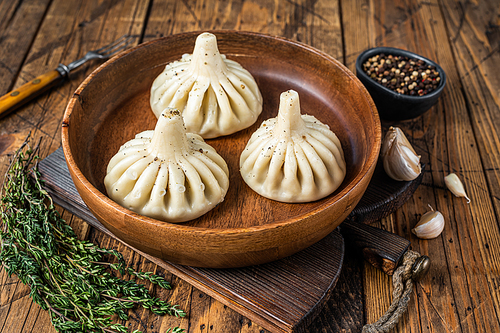 Boiled Khinkali Dumplings with mutton lamb meat in wooden plate. wooden background. Top view.