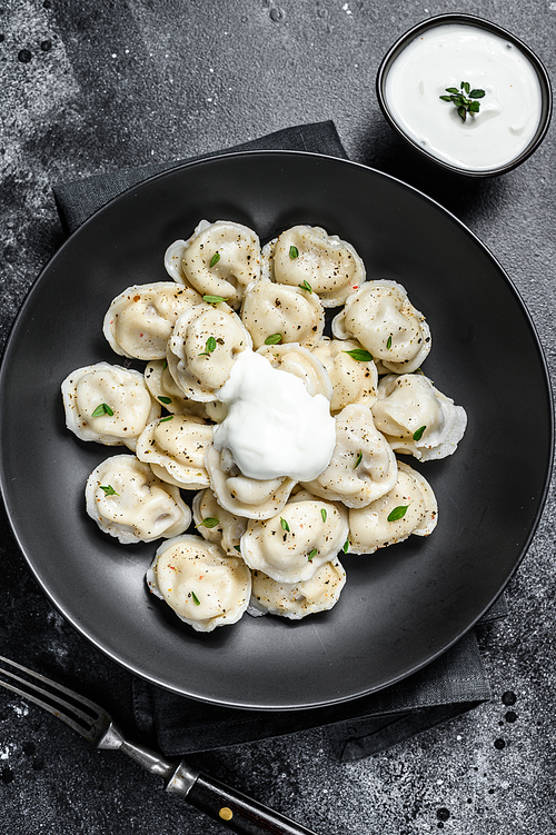 Homemade ravioli dumplings with beef and pork meat. Black background. top view.