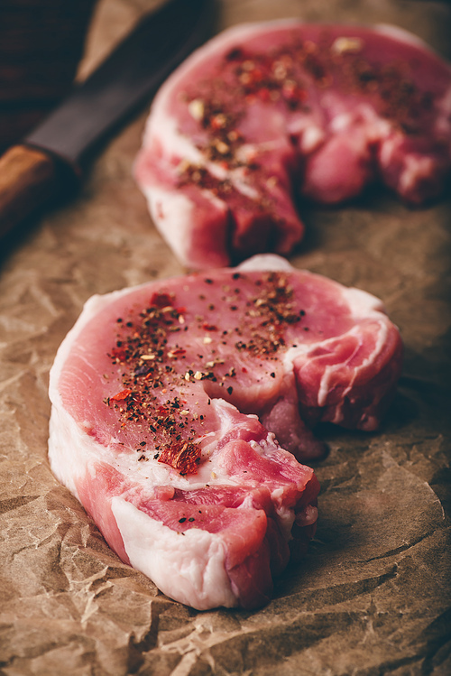 Pork loin steaks with ground spices on baking paper