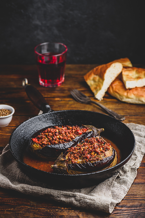Eggplants stuffed with ground beef, tomatoes and spices in frying pan. Traditional dish Karniyarik of turkish cuisine