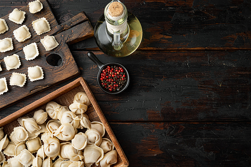 Raw Italian ravioli  tortellini with fresh parmesan and basil , tomatoes set on old dark  wooden table background, top view flat lay , with copyspace  and space for text