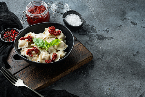 Ravioli pasta with mushroom cream sauce and cheese - Italian food style set with basil parmesan and tomatoe in black bowl, on gray background , with copyspace  and space for text