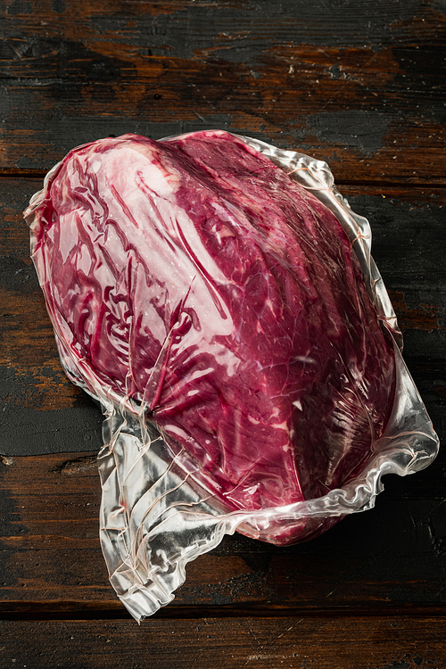 Beef meat cut in vacuum set, on old dark  wooden table background
