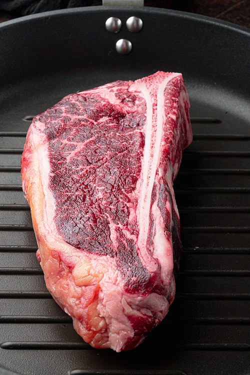 Raw fresh marbled steak entrecote of Black Angus Prime meat set, Club steak cut, on frying cast iron pan