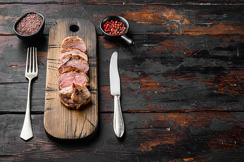 Grilled goose breast set, on wooden serving board, on old dark  wooden table background, with copyspace  and space for text