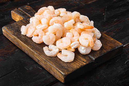 Boiled peeled shrimp prawns cooked set, on wooden serving board, on old dark  wooden table