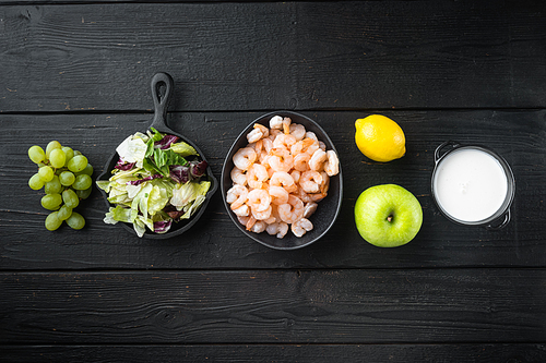 Waldorf prawn salad ingredients set, with sauce apple and grape, on black wooden table, top view flat lay, with copy space for text
