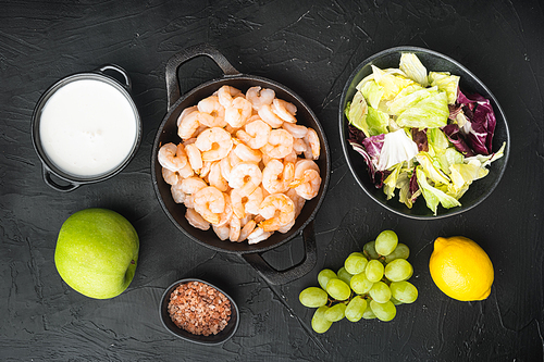 Fresh ingredients for tasty Waldorf prawn salad set, with sauce apple and grape, on black stone background, top view flat lay