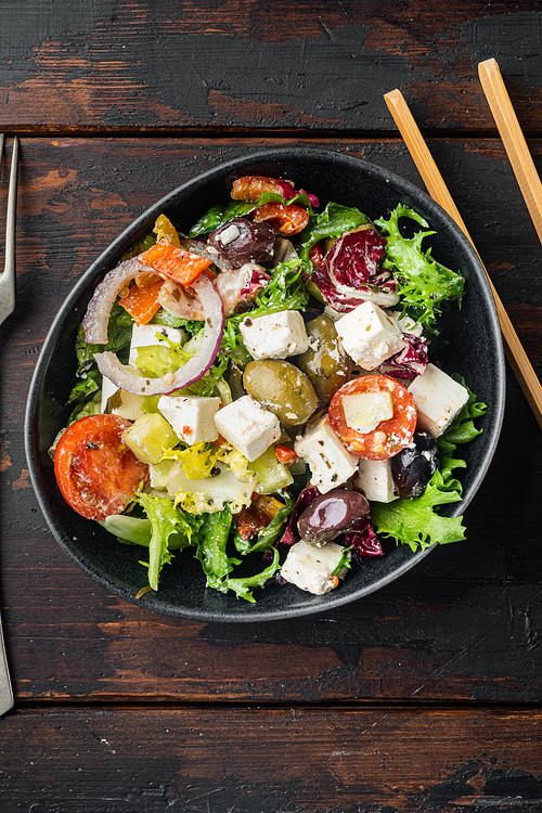 Traditional greek salad with fresh vegetables, feta and olive, on old dark  wooden table background, top view flat lay