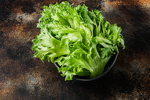Fresh organic green batavia lettuce leaves, on old dark rustic background