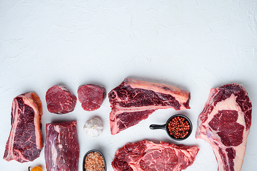 Raw beef meat steaks set, tomahawk, t bone, club steak, rib eye and tenderloin cuts, on white stone  background, top view flat lay, with copy space for text