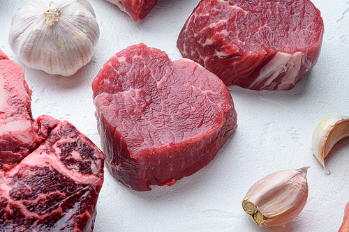 Fresh raw fillet minion steaks marbled beef with rosemary and garlic set, on white stone  surface