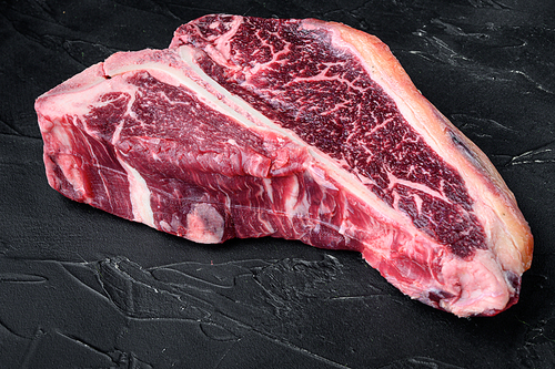 Dry-aged Raw T-bone or porterhouse beef marbled meat prime steak set, on black stone background