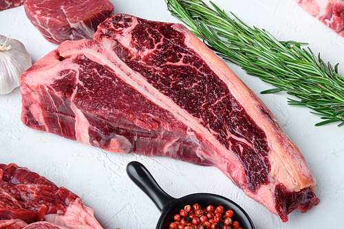 Raw fresh beef T bone steak set, on white stone  background