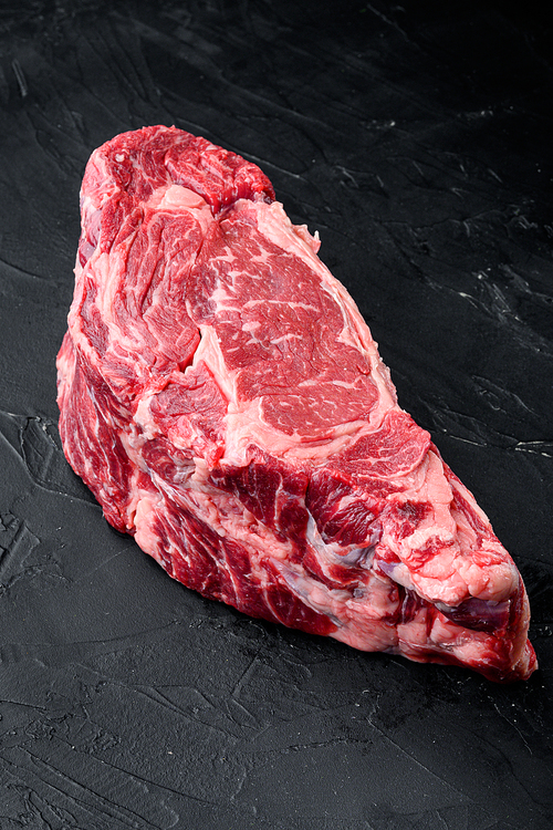 Raw Marble beef black Angus, ribeye or scotch fillet set, on black stone background