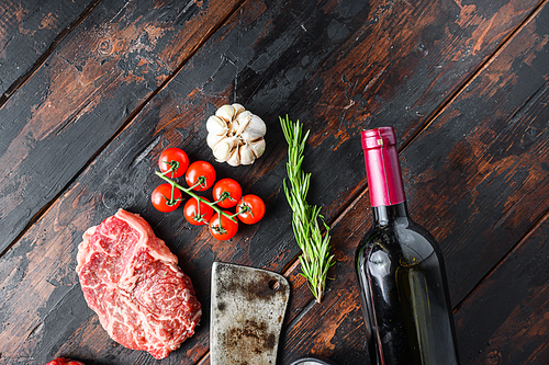 Top blade organic meat cut, raw marbled beef steak, with old butcher knife cleaver, red wine bottle  and seasonings  On dark wooden rustic table,  top view with space for text